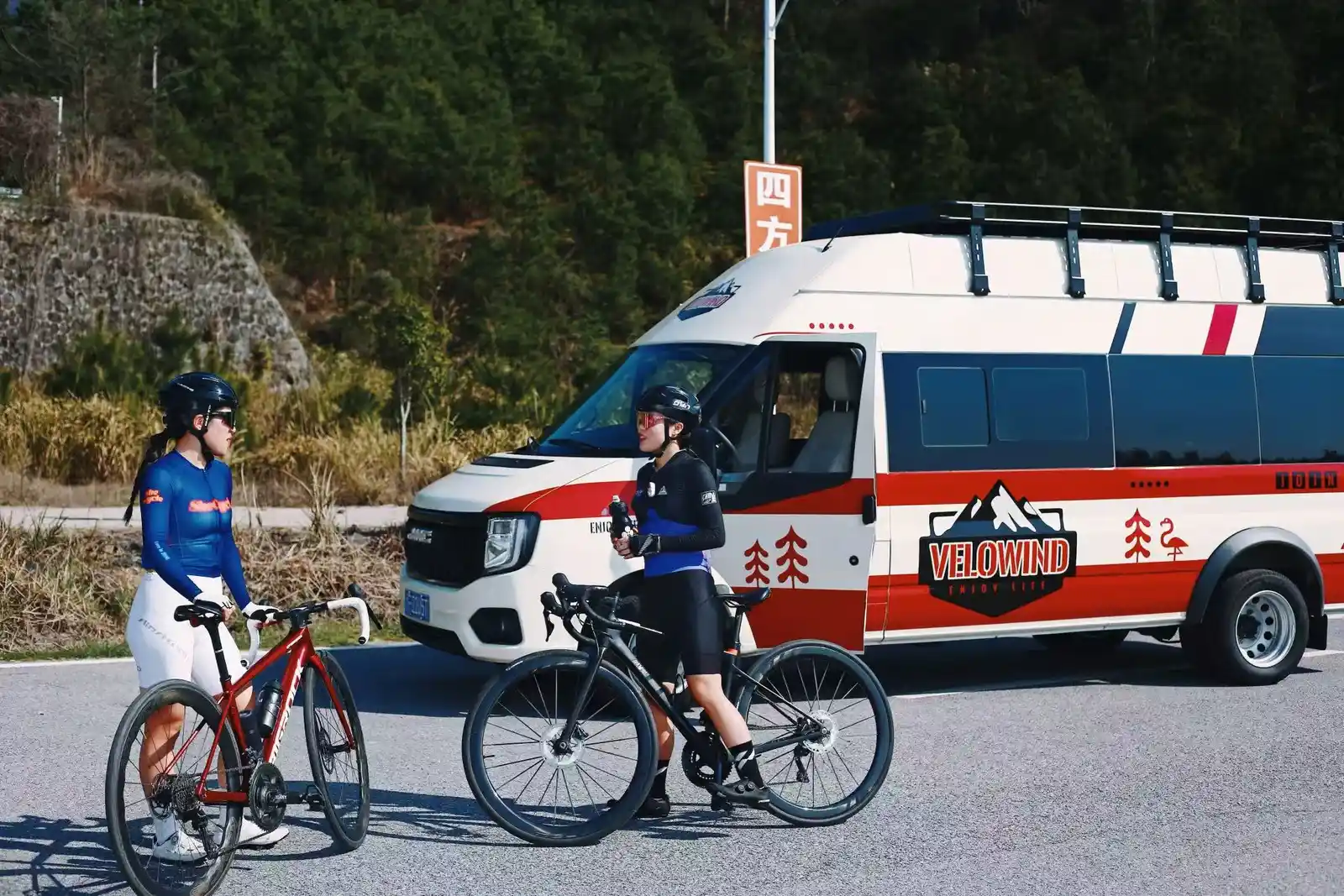 两位骑行者在 Velowind 户外运动专用车旁交流。